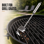 Stainless steel grill scraper collecting cooked-on residue from BBQ grates